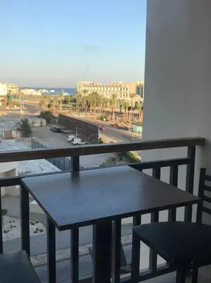 a table on a balcony with a view of a street at Al Dau Heights in Hurghada