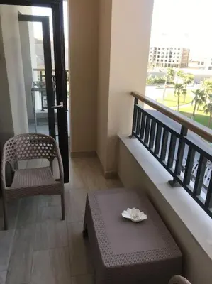 a room with a balcony with a table and a chair at Al Dau Heights in Hurghada