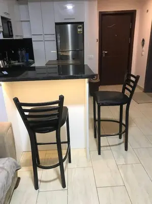 a kitchen with two chairs and a counter with a refrigerator at Al Dau Heights in Hurghada