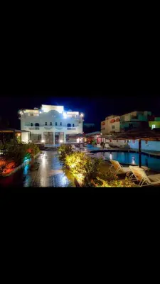 a large white building with lights in a parking lot at C and S park in Hurghada