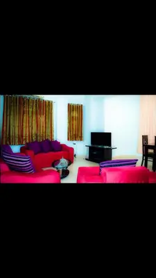 a living room with red couches and a tv at C and S park in Hurghada