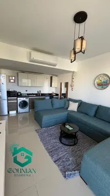 a living room with a blue couch and a kitchen at ElGouna G-cribs One Bedroom in Hurghada