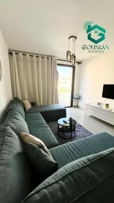 a living room with a green couch and a table at ElGouna G-cribs One Bedroom in Hurghada