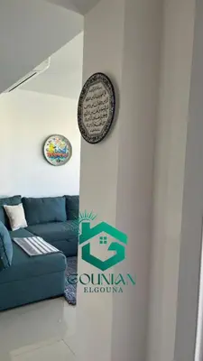 a living room with a blue couch and a sign at ElGouna G-cribs One Bedroom in Hurghada