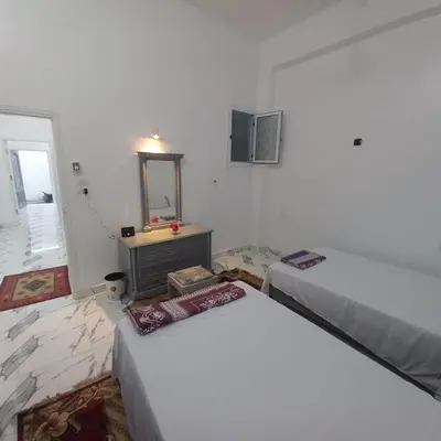 a room with two beds and a mirror in it at Nora House in Luxor