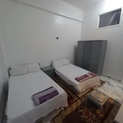 a room with two beds and a table in it at Nora House in Luxor