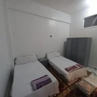 two beds in a room with white walls at Nora House in Luxor