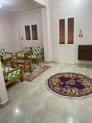 a living room with chairs and a rug on the floor at Steven in Luxor