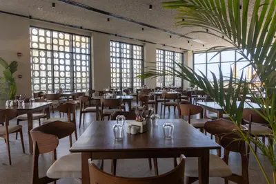 a restaurant with tables and chairs and windows at Aldiana Club Naga Bay in Hurghada