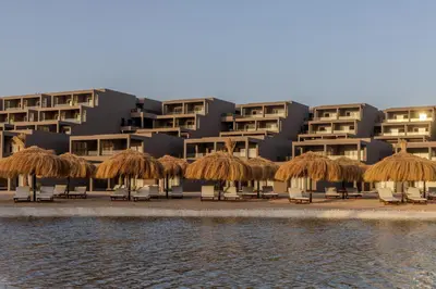 a resort with some chairs and straw umbrellas at Aldiana Club Naga Bay in Hurghada