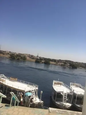two boats are docked at a dock on a river at بيت ملكه house of malaka in Naj‘ al Maḩaţţah