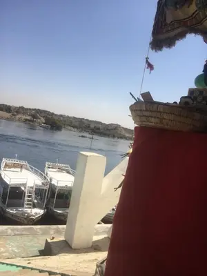 two boats are docked on the banks of a river at بيت ملكه house of malaka in Naj‘ al Maḩaţţah