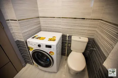 a small bathroom with a washing machine and a toilet at Wadjet-inn in Hurghada
