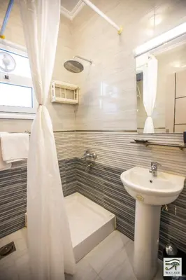 a bathroom with a sink and a toilet and a shower at Wadjet-inn in Hurghada