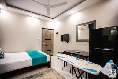 a bedroom with a bed and a desk and a tv at Wadjet-inn in Hurghada