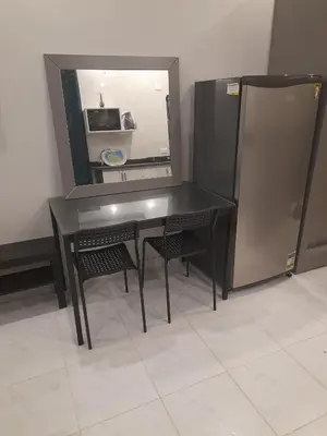 a black table with two chairs and a refrigerator at Wadjet-inn in Hurghada