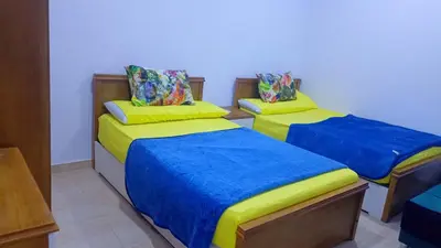 two beds in a room with blue and yellow at Tertels beach resort F 1-7 in Hurghada