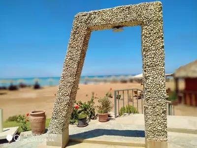 a stone archway with potted plants on a beach at Tertels beach resort F 1-7 in Hurghada
