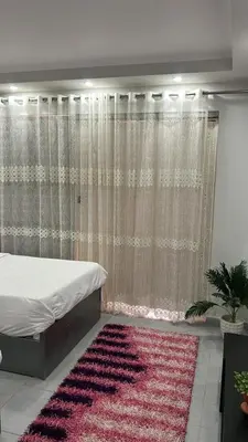 a bedroom with a bed and a pink rug at scandic resort 647 in Hurghada
