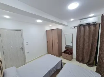 a bedroom with a bed and a closet and a mirror at Mabed in Hurghada