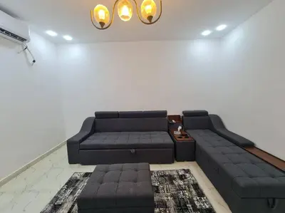 a living room with a black couch and a table at Mabed in Hurghada