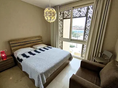 a bedroom with a bed and a couch and a window at SunShine Mangrove in Hurghada