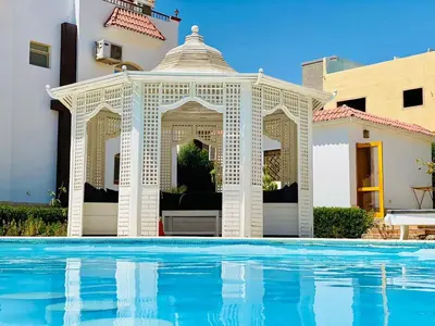 an outdoor gazebo next to a swimming pool at hurgada hapy room in Hurghada