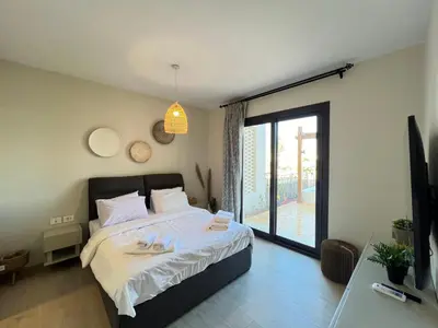 a bedroom with a bed with two slippers on it at Stylish 1BR Ground With Free Pool & Lagoon Access In Gouna in Hurghada