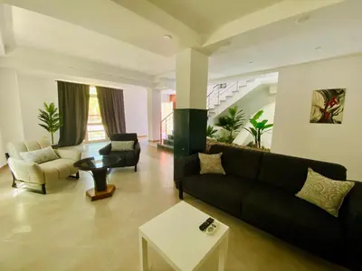 a living room with a black couch and a table at Hurghada - Magawish Villa 3 in Hurghada