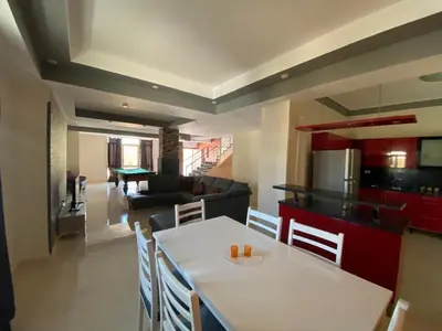 a kitchen and a living room with a table and chairs at Hurghada - Magawish Villa 3 in Hurghada