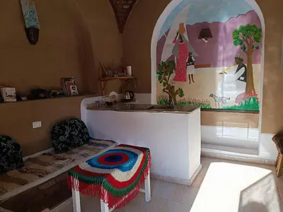 a room with a table and two chairs and a painting at Dream house in Luxor