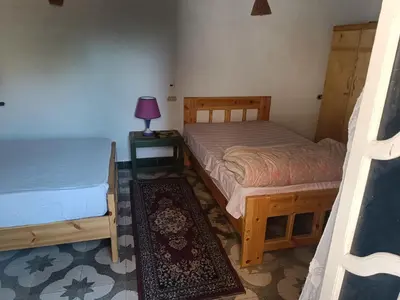 a bedroom with two beds and a table with a lamp at Dream house in Luxor