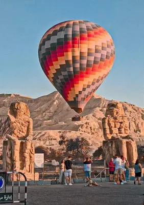 a hot air balloon flying over a group of people at Dream house in Luxor