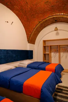 two beds in a room with a brick wall at JAREEDY Guest house in Shellal