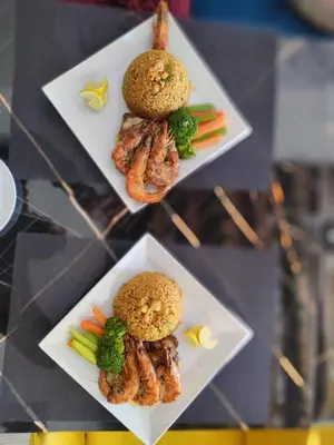 two plates of food with shrimp and vegetables on them at Hotel apartment with a private beach in Hurghada