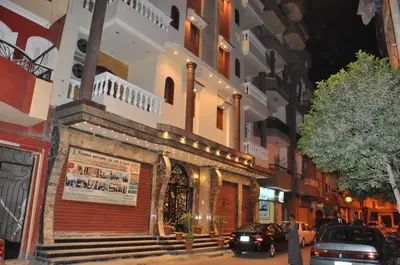 a street with cars parked in front of a building at Eye of Horus House in Luxor