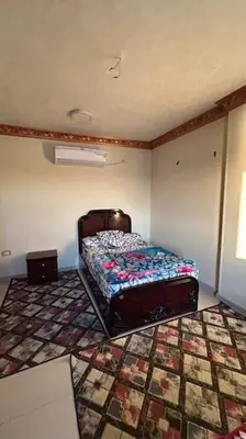a bedroom with a bed in the corner of a room at The best view of the Nile in Naj‘ al ‘Amrāb