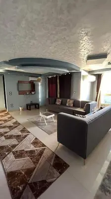 a living room with a couch and a table at The best view of the Nile in Naj‘ al ‘Amrāb