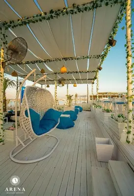 a deck with blue chairs and an umbrella at Colin beach in Hurghada