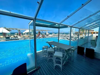 a deck with a table and chairs next to a swimming pool at Colin beach in Hurghada