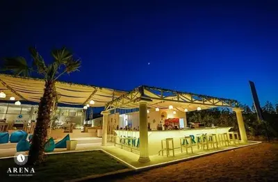 a pavilion with a bar and a palm tree at night at Colin beach in Hurghada