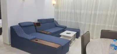 a living room with a blue couch and a table at Hurghada celina branch & resort in Hurghada
