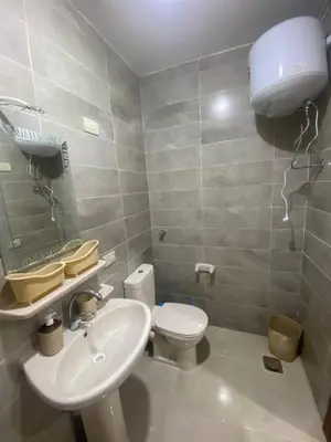 a bathroom with a white toilet and a sink at Tiba Golden Resort in Hurghada
