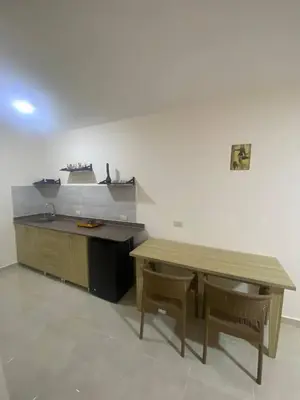 a kitchen with a wooden table and two chairs at Tiba Golden Resort in Hurghada