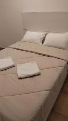 two beds with white sheets and two towels on them at Sharqotel Luxor in Luxor