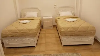 two beds in a small room with at Sharqotel Luxor in Luxor