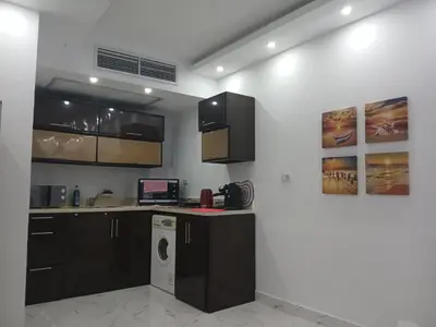 a kitchen with black cabinets and a washer at Red Sea Hurghada Summer in Winter in Hurghada