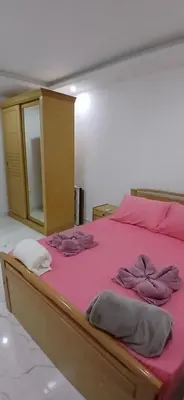 a bed with pink sheets and pillows on it at Red Sea Hurghada Summer in Winter in Hurghada