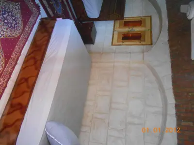 a bedroom with a bed and a wooden table at Hashem Nubian Guest House in Aswan