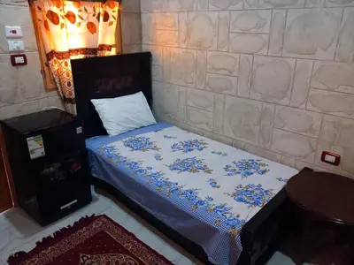 a bedroom with a bed with blue and white sheets at Hashem Nubian Guest House in Aswan